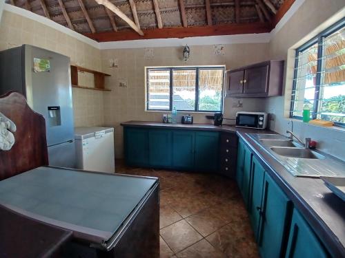 a kitchen with blue cabinets and a counter top at Seadeck, Barra Mozambique in Inhambane