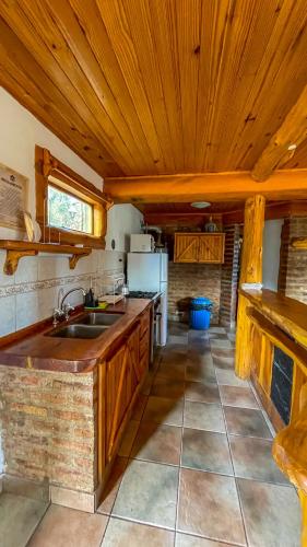 a kitchen with a wooden ceiling and a sink at Complejo Don Cirilo in Villa Pehuenia