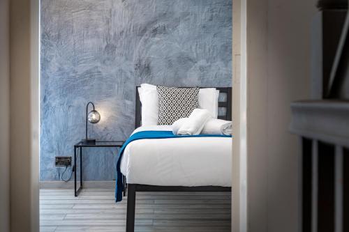 a bedroom with a bed with a blue wall at Modern City Centre Townhouse sleeps 10 & Parking in Manchester