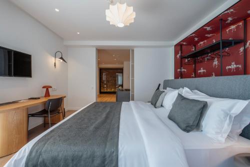 a bedroom with a large bed and a desk at Artifact Apart Hotel in Tbilisi City
