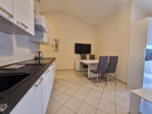 une cuisine avec une table et des chaises dans une pièce dans l'établissement Blue Horizon - 400m from the Sea!, à Dramalj