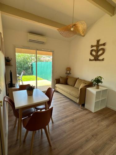 un salon avec une table et un canapé dans l'établissement Maison de vacances en Camargue, à Aigues-Mortes
