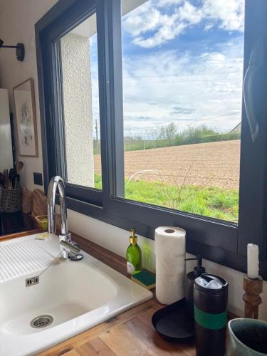 d'un évier de cuisine avec une fenêtre donnant sur un champ. dans l'établissement Cottage romantique dans les champs, à Bonsmoulins