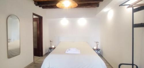 a white bedroom with a bed and a mirror at Menta Cinque Terre in Vernazza