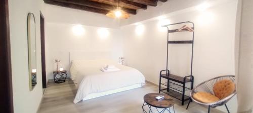 a white bedroom with a bed and a table and chairs at Menta Cinque Terre in Vernazza