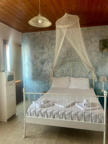 a bedroom with a white bed with a canopy at APARMENTS Elina in Potamiá