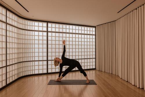 a woman doing a yoga pose in a room at Perianth Hotel, a Member of Design Hotels in Athens