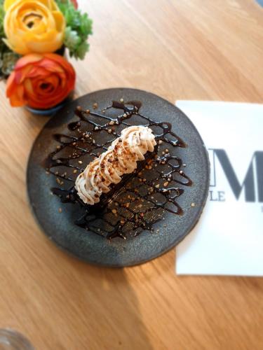 a plate with a piece of food on a table at Le M & Spa Bordeaux Aéroport by Hôtels & Préférence in Mérignac