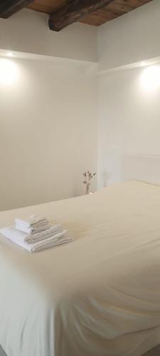 a white bed with white sheets and towels on it at Menta Cinque Terre in Vernazza