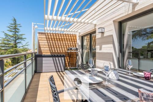 un patio avec une table et des chaises sur un balcon dans l'établissement Appartement avec grande terrasse et spa à Lattes, à Lattes