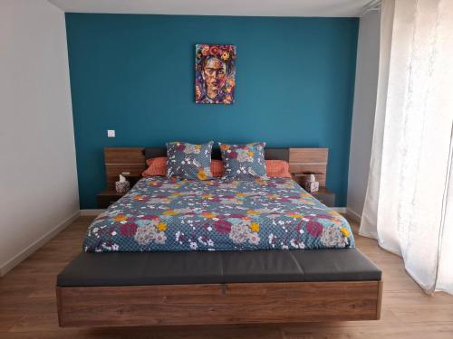a bedroom with a bed with a blue wall at La suite de la route des vins in Arsac