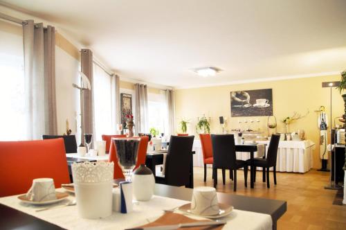 Park Ambiente Friedberg في فريدبرغ: مطعم بطاولات وكراسي وغرفة طعام