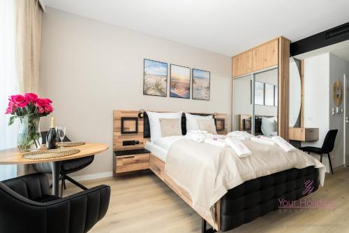 Un dormitorio con una cama, un escritorio y una mesa. en Your Holidays Infinity B413, en Międzyzdroje