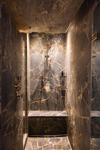 a bathroom with a stone wall with a shower at Jungbrunn Der Gutzeitort in Tannheim