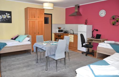 a room with a dining table and a kitchen and a bedroom at Apartamenty Głowackiego in Sosnowiec