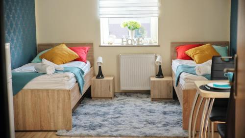 a bedroom with two beds and a window at Apartamenty Głowackiego in Sosnowiec