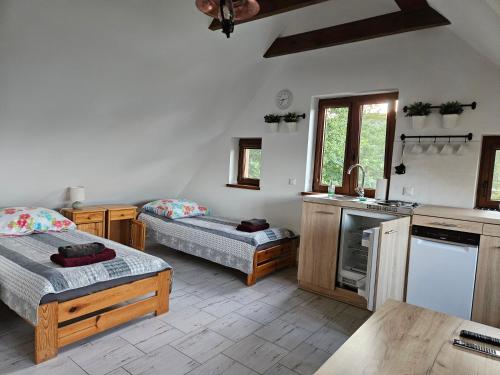 a room with two beds and a kitchen at Chata Pod Strzechą in Lipusz