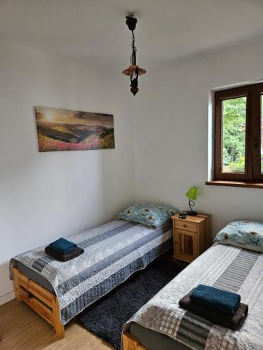two twin beds in a room with a window at Chata Pod Strzechą in Lipusz
