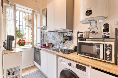 une cuisine avec un lave-linge et un micro-ondes dans l'établissement Maison Brumani - Happy Rentals, à Menton