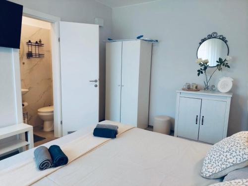 a bedroom with a large white bed with a mirror at Kosovic Family House in Medulin