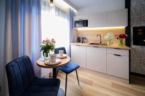 małą kuchnię ze stołem i niebieskim krzesłem w obiekcie Apartamenty i Pokoje Złotobrzeg w Sarbinowie