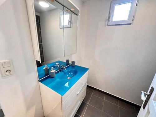 une salle de bain avec un lavabo bleu et un miroir dans l'établissement Le repère dAlice T2 cosy proche centre, à Reims