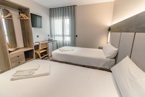 a hotel room with two beds and a desk at HOTEL RURAL FINCA LA DESA in Miajadas