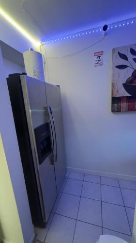 a small kitchen with a refrigerator with a purple ceiling at Hotel Room 2 in Coquitlam
