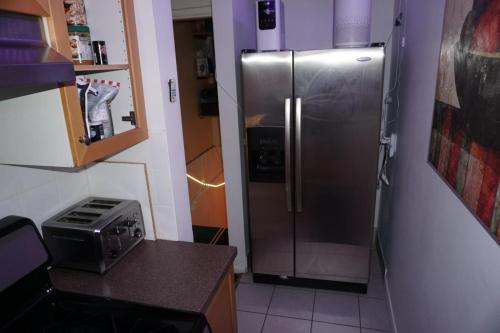 a kitchen with a stainless steel refrigerator in the corner at Hotel Room 2 in Coquitlam