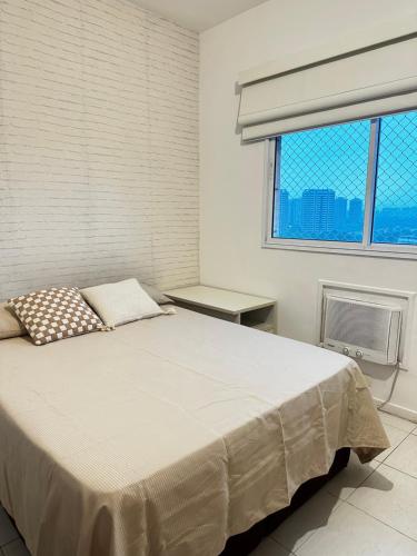 Un dormitorio blanco con una cama y una ventana. en Barra da Tijuca Rio Centro Recreio Praia, en Río de Janeiro