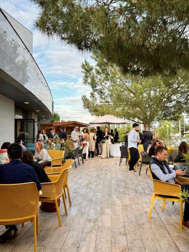 a group of people sitting in chairs on a patio at Le M & Spa Bordeaux Aéroport by Hôtels & Préférence in Mérignac