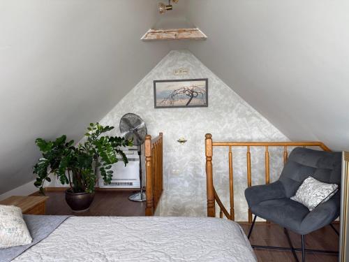 a room with a bed and a chair at Vila Preiloja in Neringa