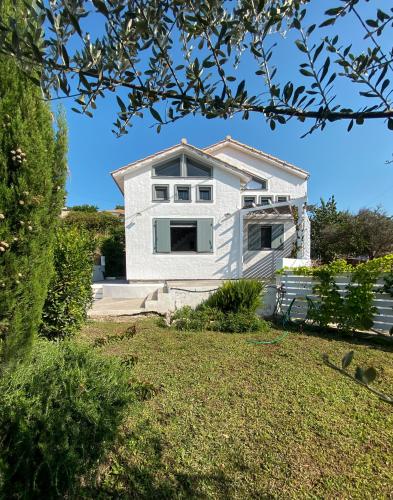 a white house with a yard at Ληγάτο Cottage House in Áyios Pétros