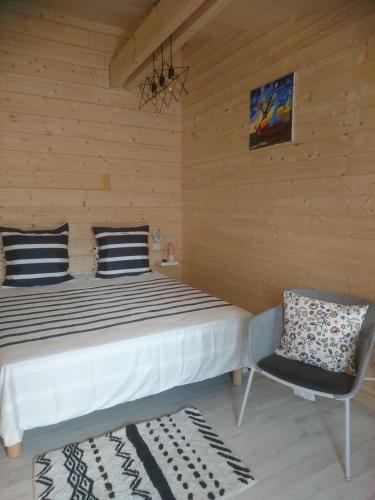 une chambre avec un lit et une chaise dans l'établissement La Crapouillette, à Lège-Cap-Ferret