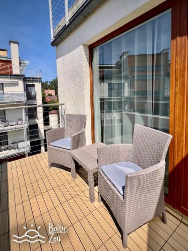 a patio with chairs and tables on a balcony at Baltic Zen II - Apartament in Hel