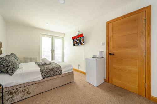 a bedroom with a bed and a wooden door at -RF7B- For your relaxed and Cosy stay with Free WiFi in Batley