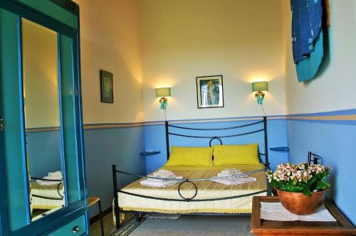 イスピカにあるVinciucciのベッドルーム1室(黄色い枕と鏡付きのベッド1台付)