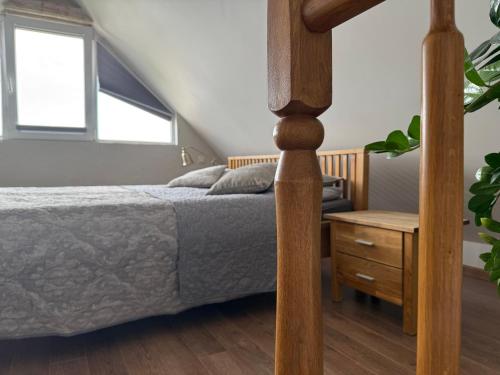 a bedroom with a bed and a wooden floor at Vila Preiloja in Neringa