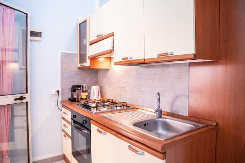 a small kitchen with a sink and a stove at Casa Josto a due passi da Spiaggia Maladroxia in Maladroxia