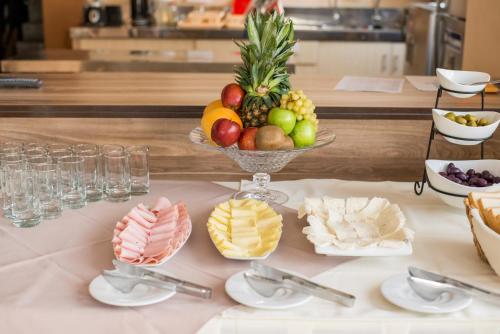 a table with a bowl of fruit and other desserts at Hotel PLATINIUM in Tacna
