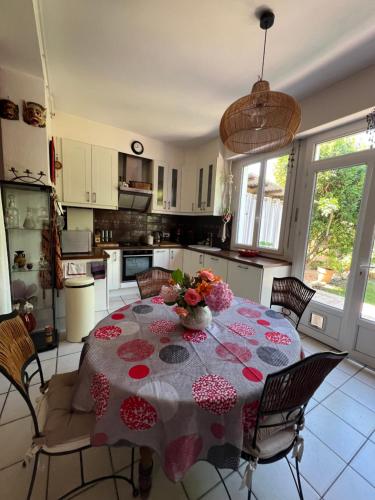 - une cuisine avec une table et des fleurs dans l'établissement Échoppe bordelaise avec jardin, à Talence