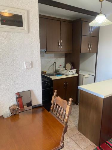 a kitchen with a wooden table and a counter top at To σαλέ της λίμνης 2 in Kalyvia Fylaktis