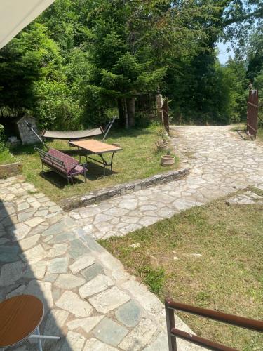 a patio with a picnic table and a bench at To σαλέ της λίμνης 2 in Kalyvia Fylaktis