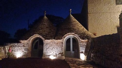 a building with a pointed roof at night at Masseria Mazzalorsa in Alberobello
