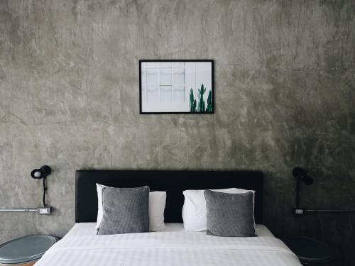 a bedroom with a bed with a picture on the wall at Khao Yai Cottage in Mu Si