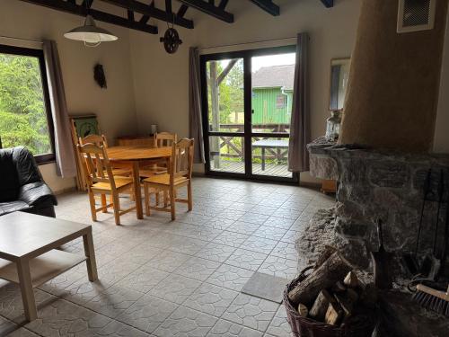 a living room with a table and a fireplace at Żurawia Łąka in Bytów