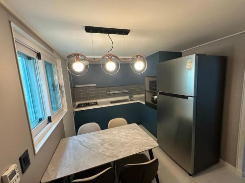 una cocina con una mesa y un refrigerador en Laon Haje, Joyful Tomorrow, en Buyeo