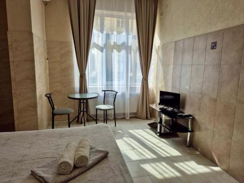 a hotel room with a bed and a table and chairs at Pechersk House in Kyiv