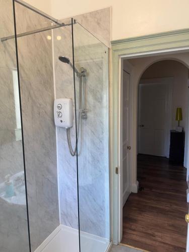 a shower with a glass door in a bathroom at 52, Charlotte Street Apartments in Glasgow