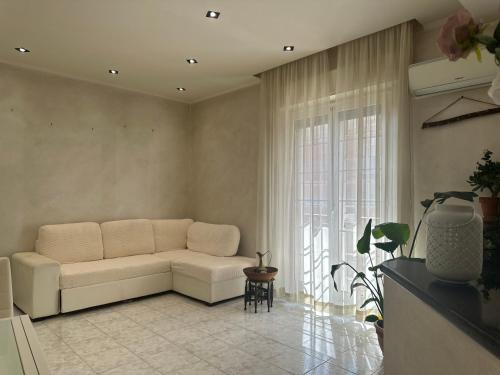 a living room with a white couch and a window at Casa Liliana in Ladispoli